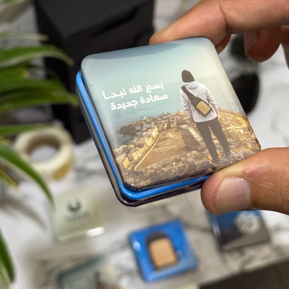Hand placing a photo magnet on a fridge door – shows size and usability.